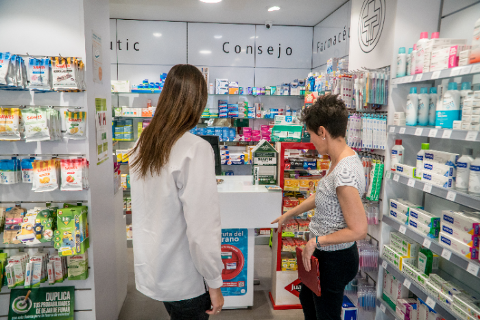 Dos mujeres en una farmacia trabajando para mejorar el punto de venta de una marca